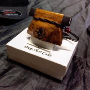 Red Cedar Bell Call by DropShot with lanyard and red bead on white gift box.