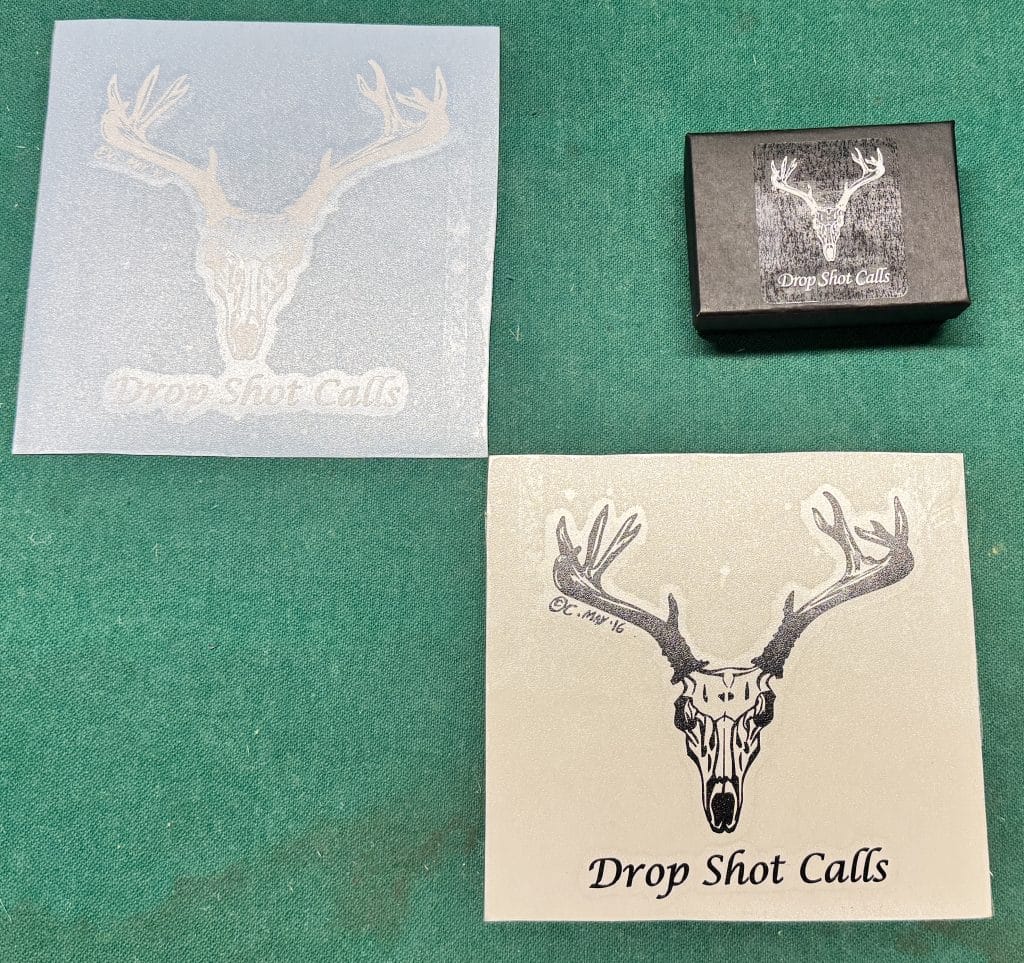 Translucent white Small DropShot Decal with deer skull logo and DropShot Calls text on green surface.